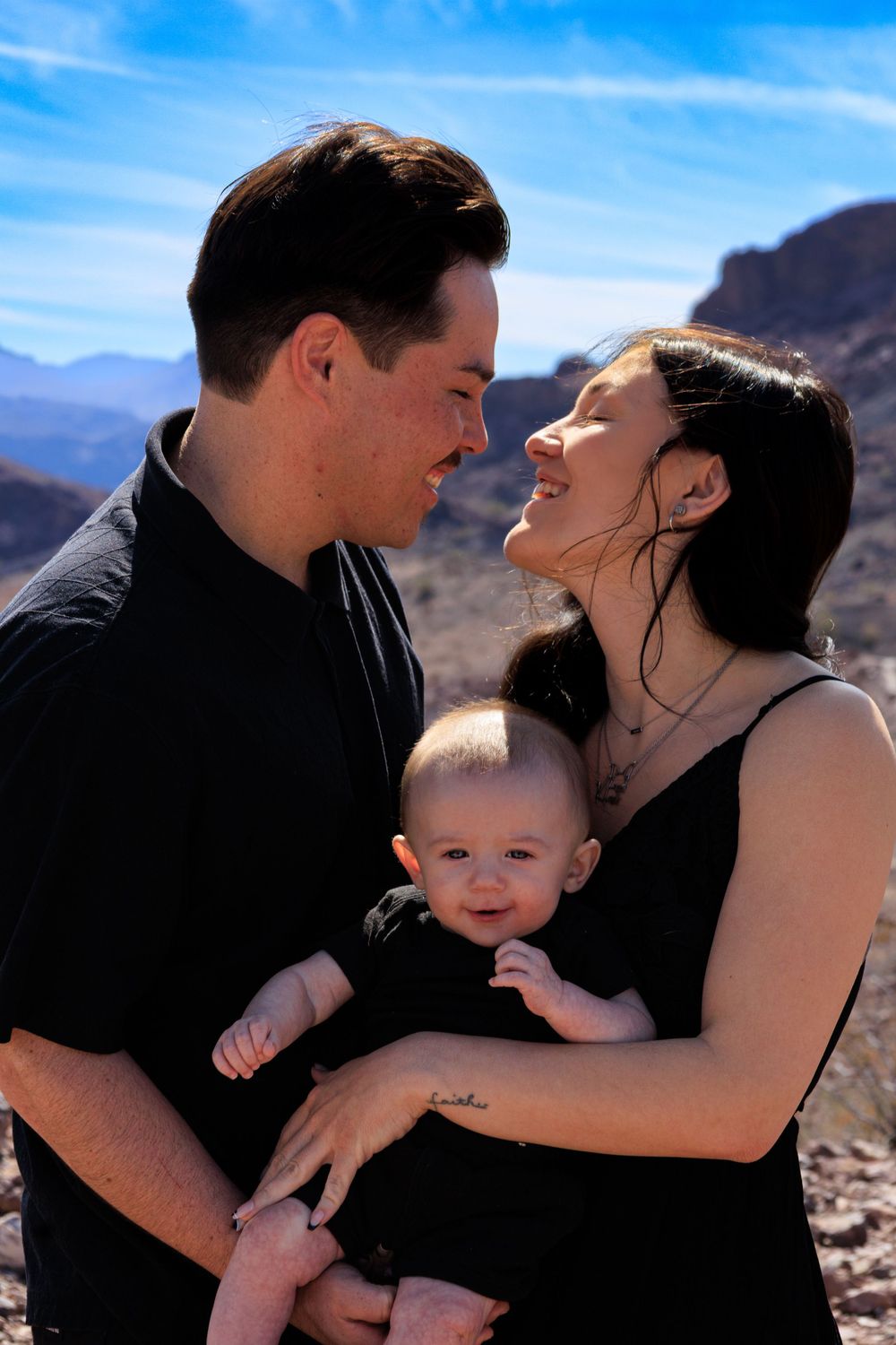 Family sharing intimate moments together against desert mountain backdrop.