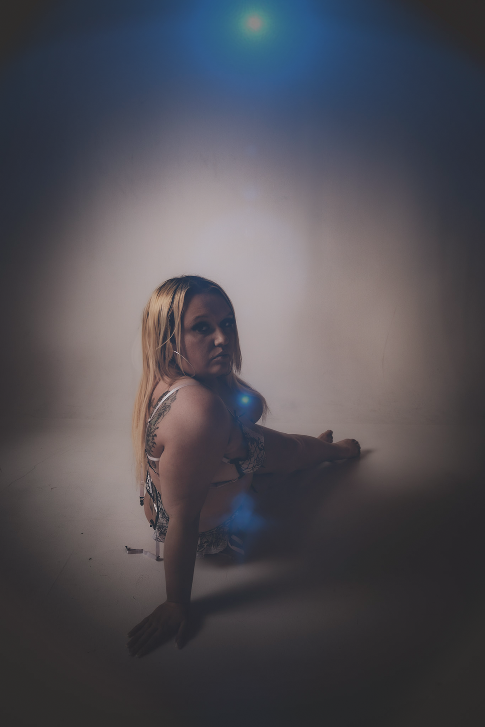 Artistic portrait with dramatic blue lighting and soft focus effects.