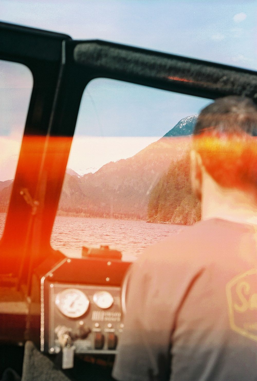 Multiple exposure photo of mountain scenery with sunset glow through car windows.