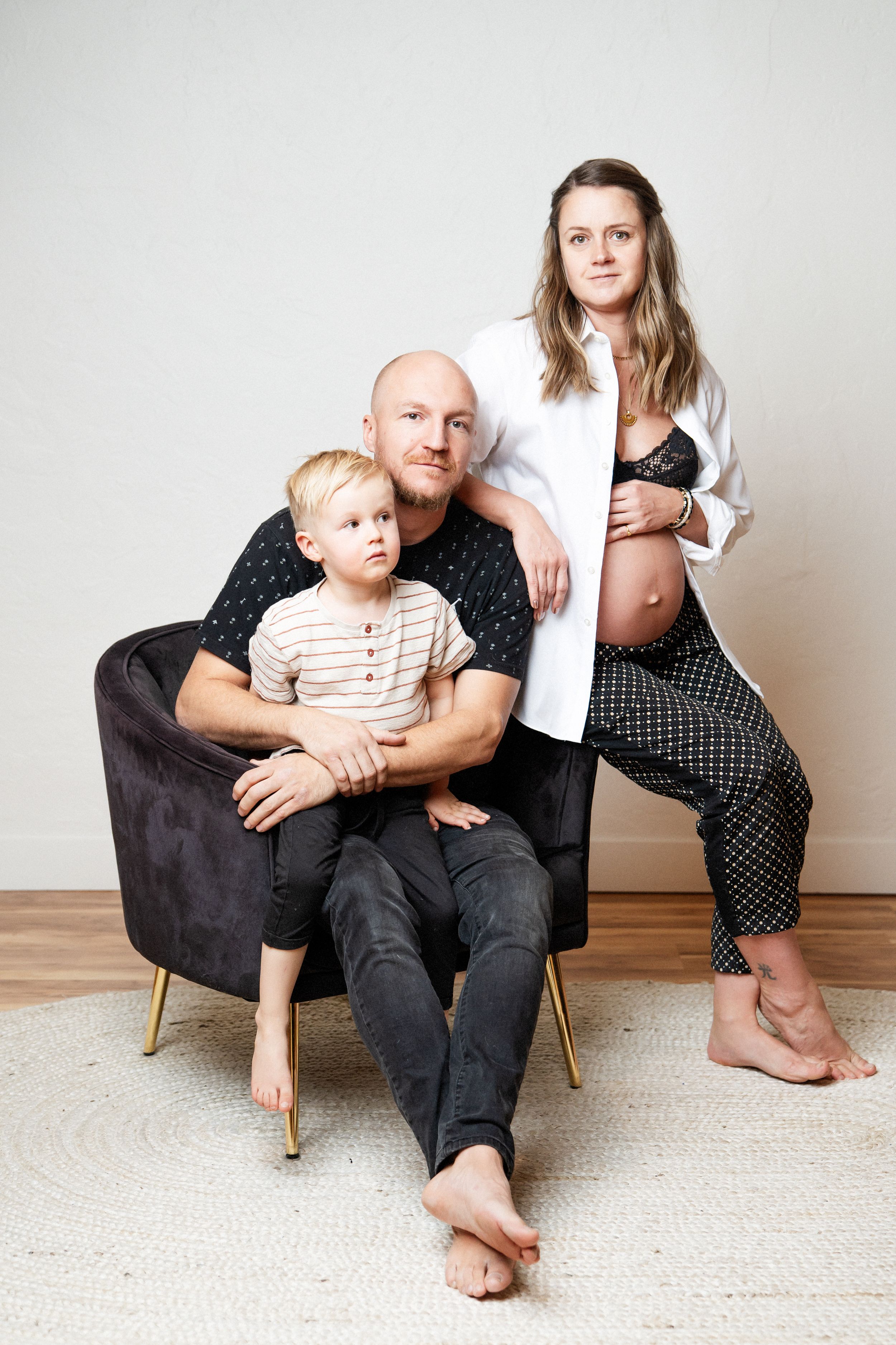 Contemporary family portrait in minimalist setting with modern furniture and natural lighting.