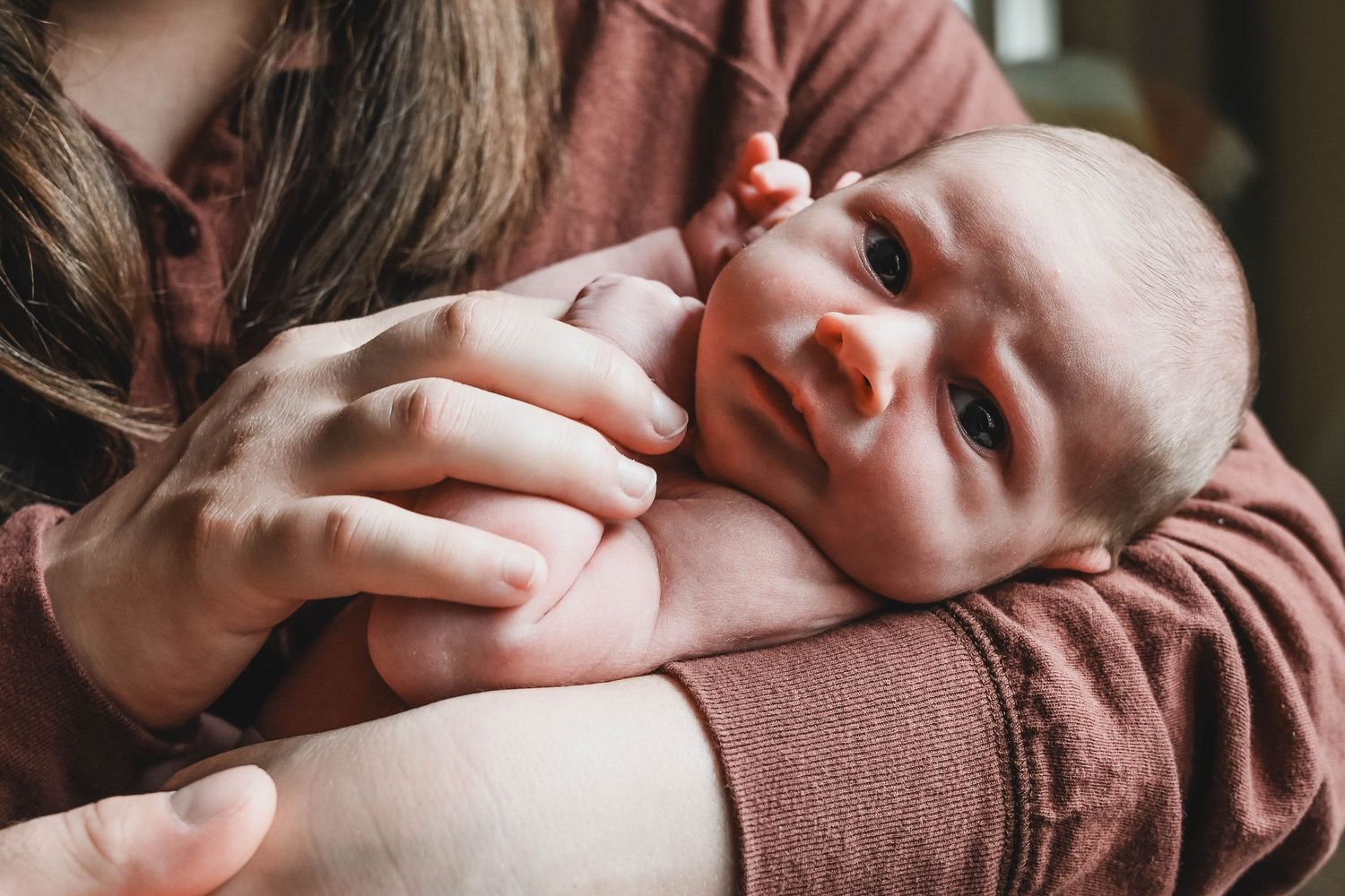 Newborn baby girl looks into the camera during a Troy NY session with K. Manchuck Photography