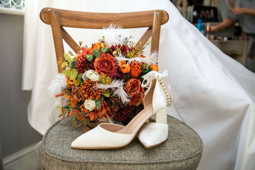 Wedding shoes and autumn-colored bouquet arranged on a stone surface.
The Plough Inn