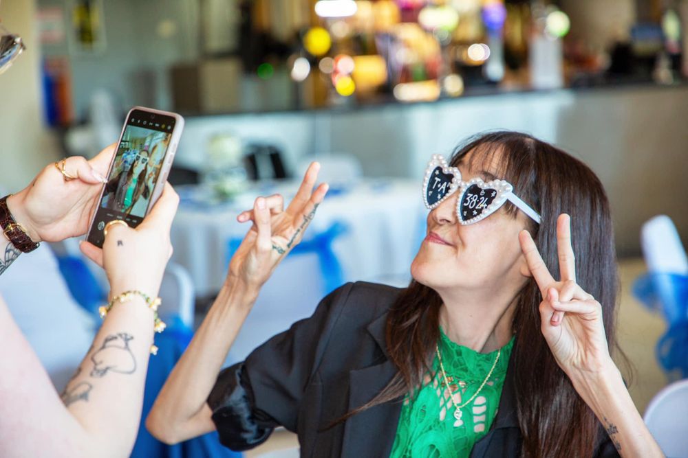 Wedding reception guests taking photos with their phones during celebration.