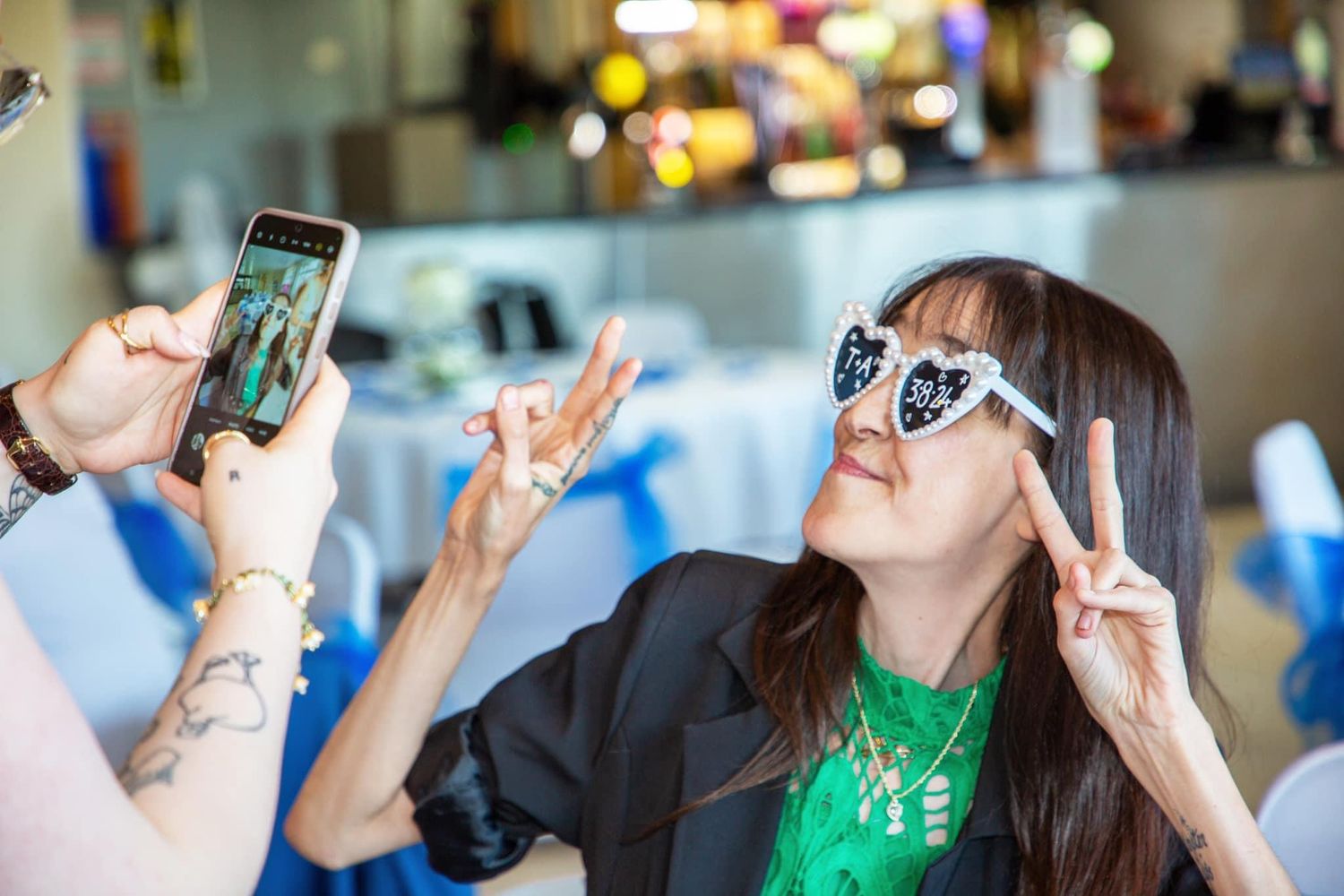 Wedding reception guests taking photos with their phones during celebration.