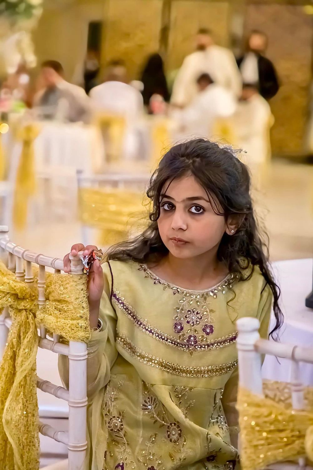Person in a beige embellished dress seated at an elegant table setting.