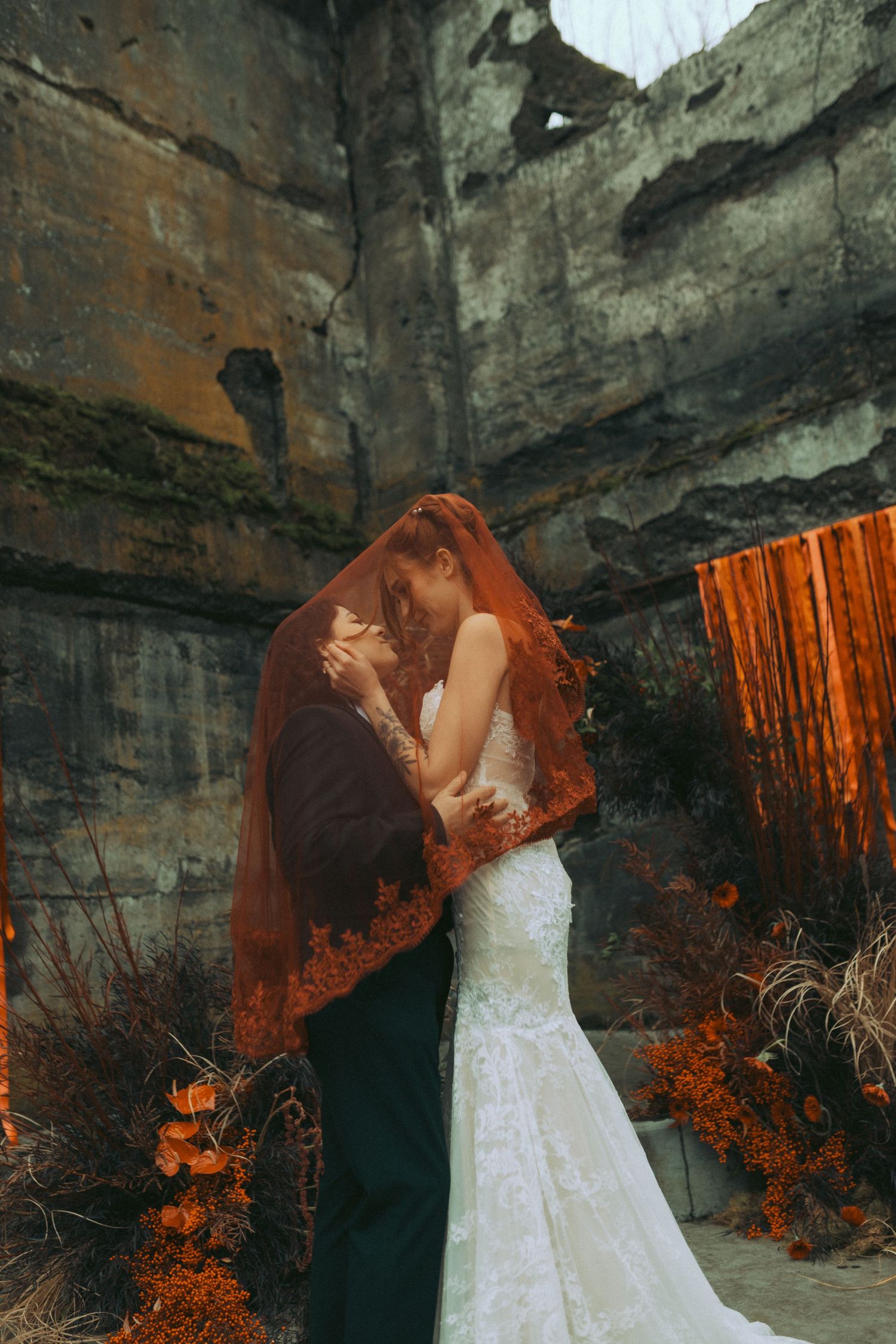 A figure in a white wedding dress poses dramatically against a rocky cave wall with warm orange lighting effects.