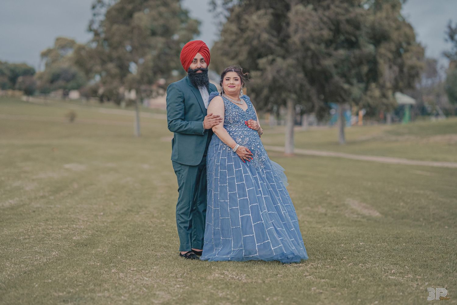 Pregnant woman and her partner smiling and posing together, capturing a joyful moment during their maternity photoshoot.