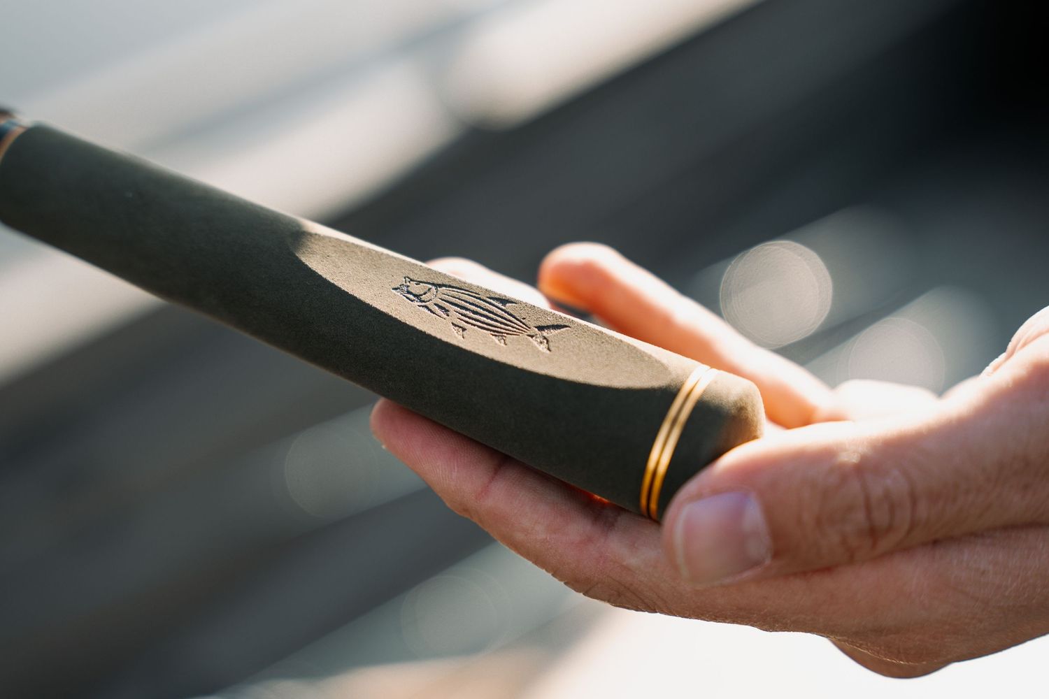 Close up of hands holding vintage fishing reel with selective focus.