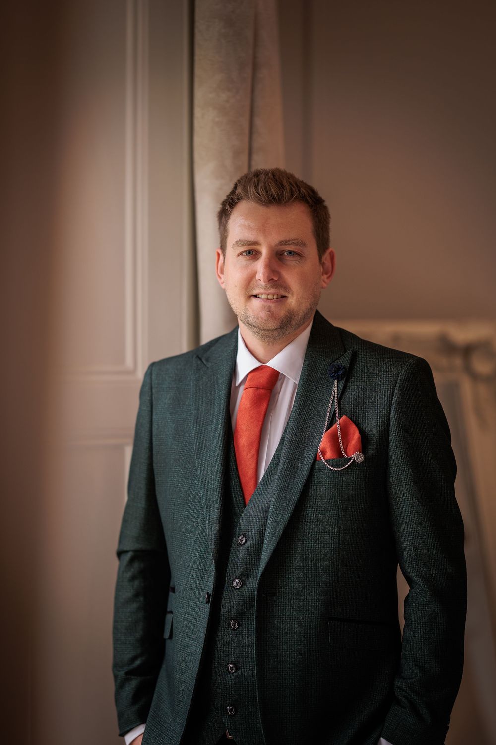Professional portrait series showing a person in a dark suit with red tie and pocket square against a neutral background.