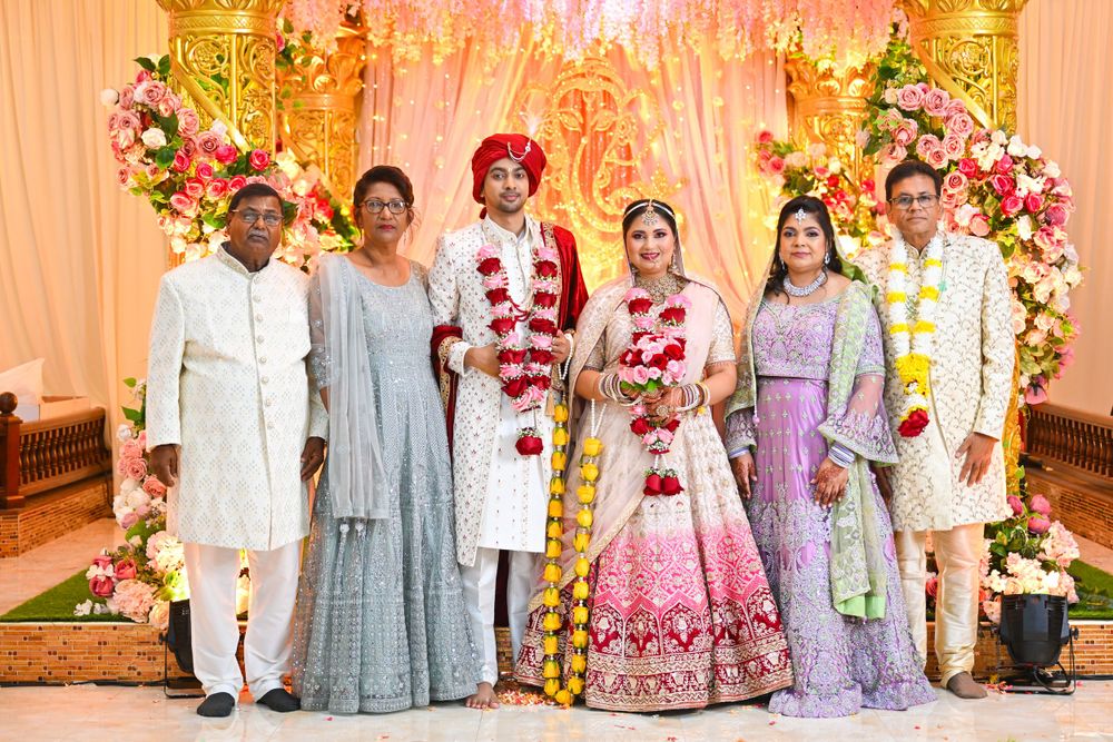 Traditional Indian wedding group photo with family members in colorful ethnic attire.