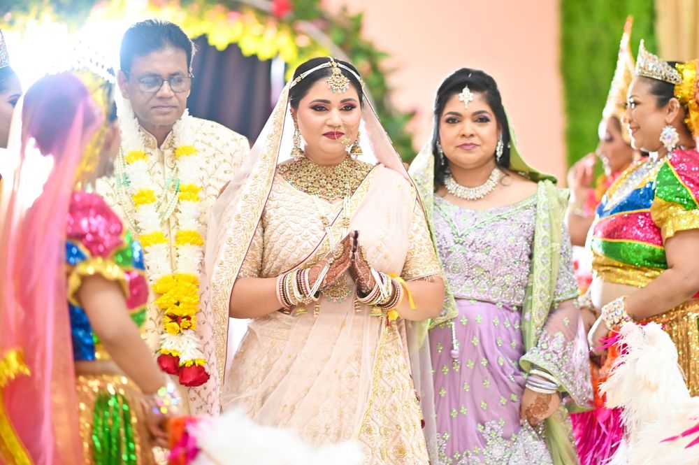 Traditional Indian wedding ceremony with bride in peach lehenga surrounded by guests.