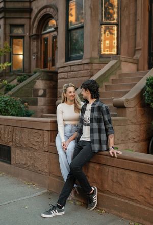 Couple sitting on brownstone steps in Brooklyn during golden hour sharing intimate moments together.