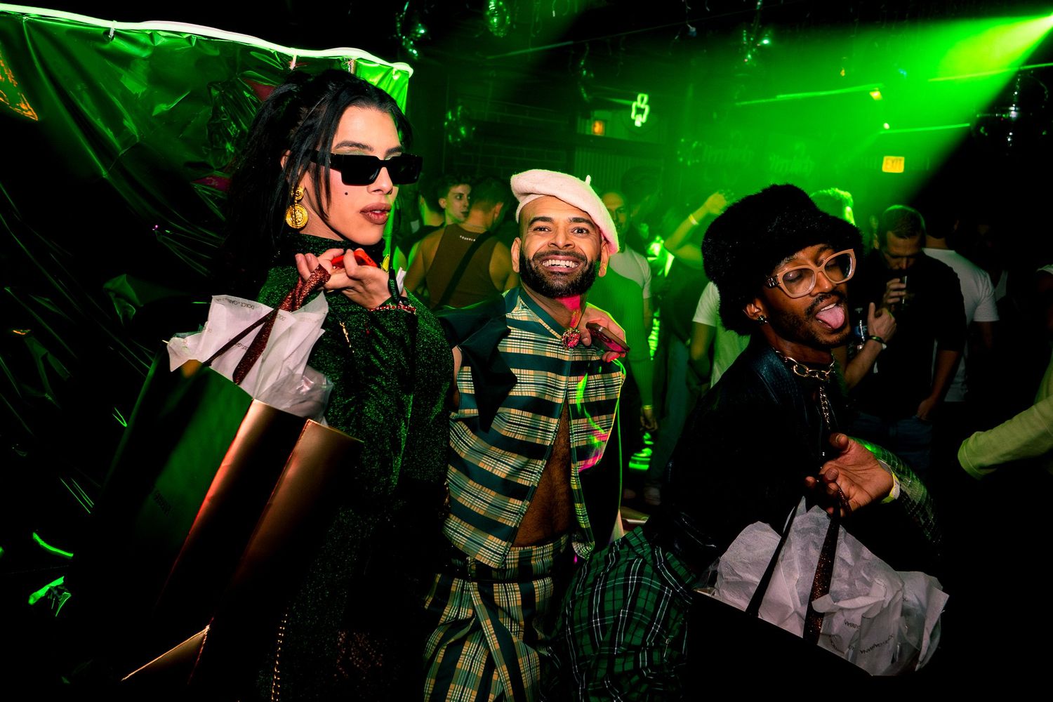 Three people pose at a nightlife event hosted by Dusty Carpenter at DS Tequila showing off their outfits on St. Patricks Day
