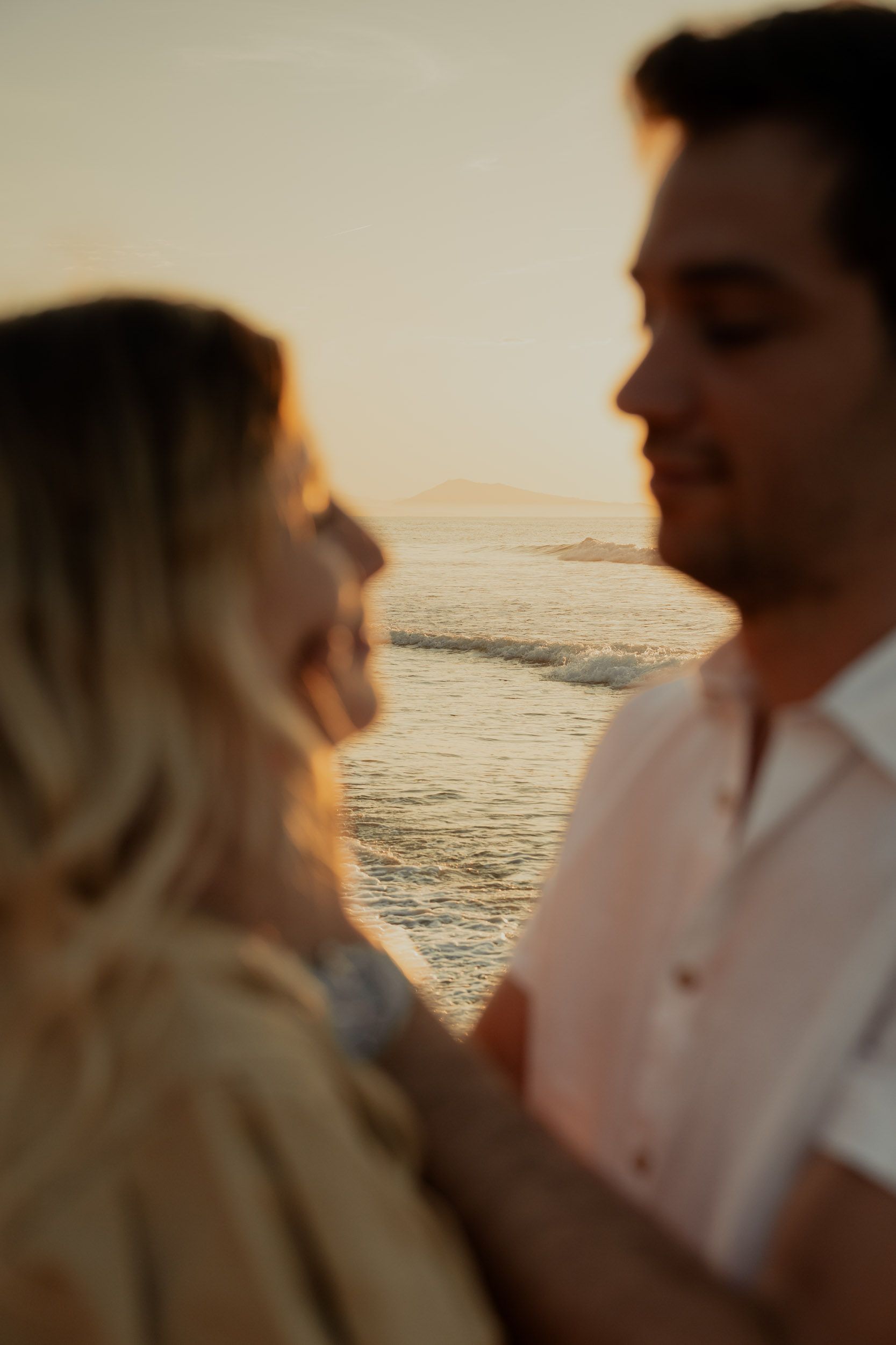 Romantic silhouettes against a sunset ocean backdrop.