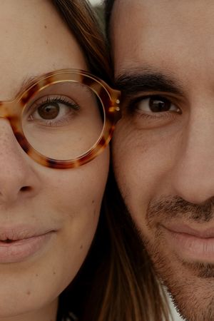 Close-up portrait showing partial faces and tortoise shell glasses.
