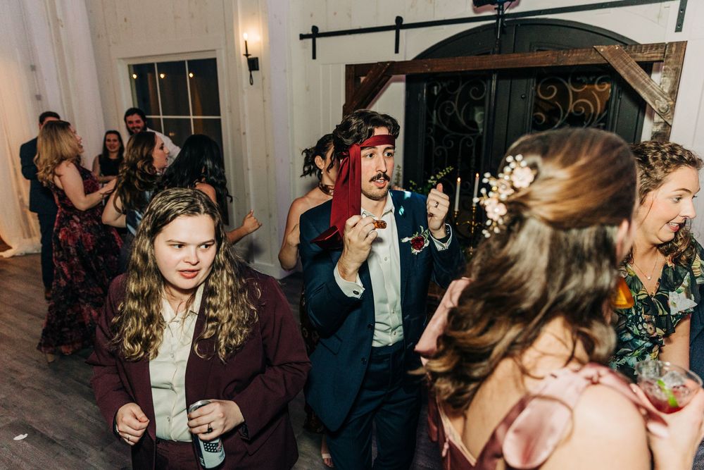 A lively dance party scene at a nightclub with people dancing and socializing under dim lighting.