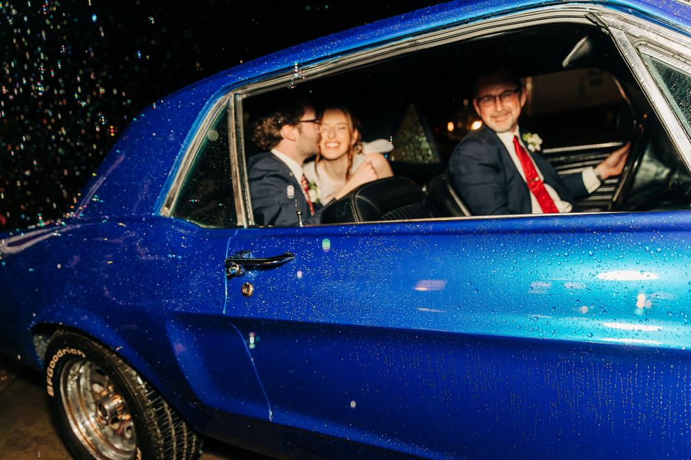 A series of nighttime shots showing a classic blue car departing from an evening celebration.