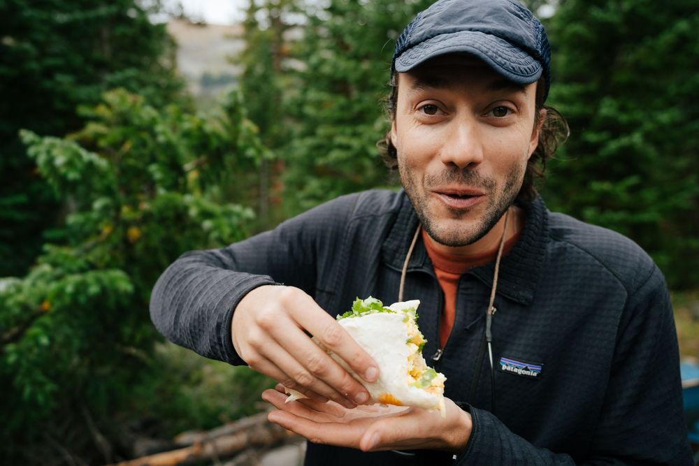 A series of outdoor camping scenes showing hands preparing and enjoying food in a forest setting.