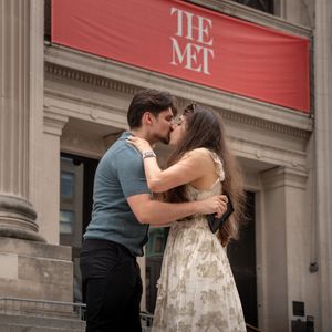 Couple kissing on the steps of The Metropolitan Museum of Art in New York City.