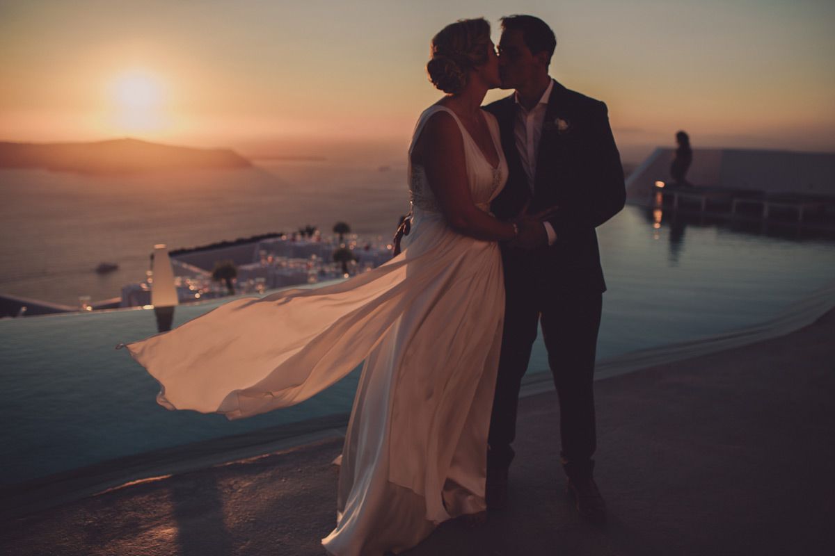 Couple at sunset by infinity pool during a wedding at Grace Santorini