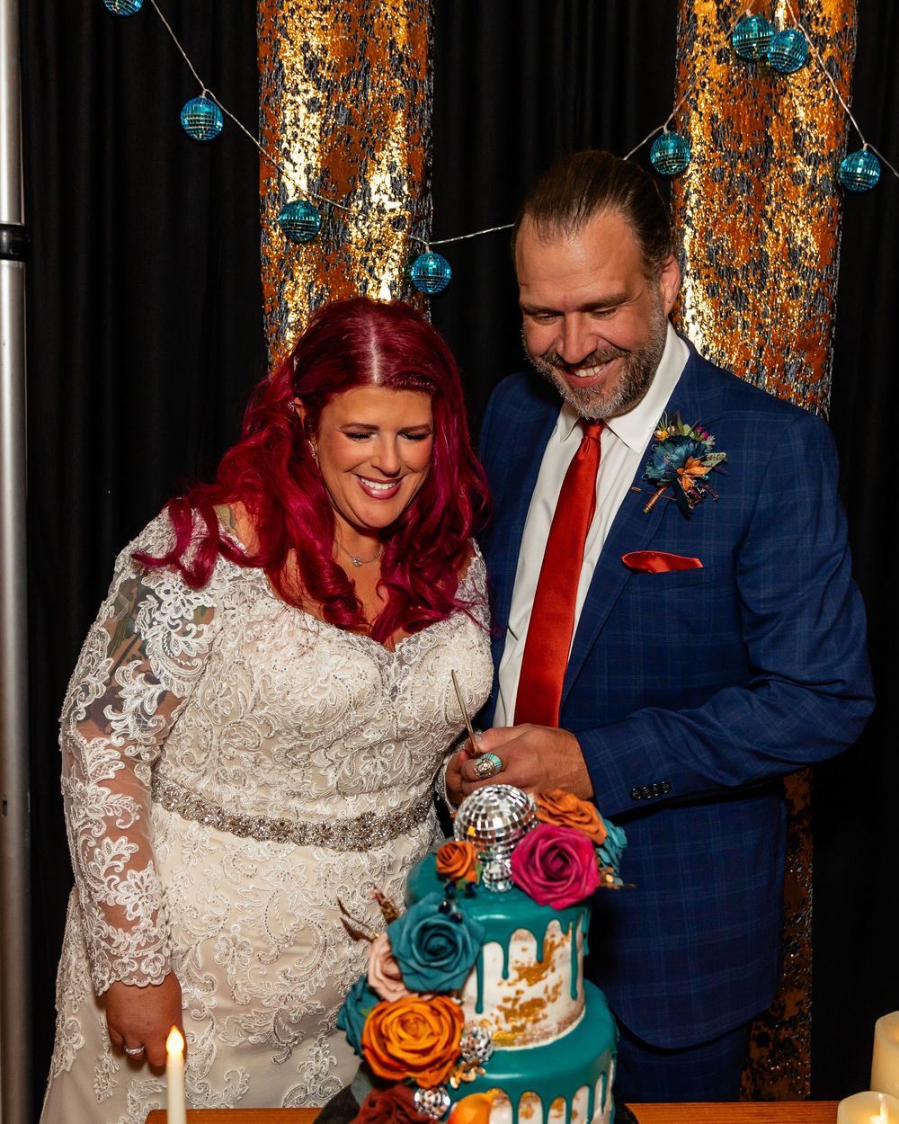 Bride and groom cut colorful wedding cake with teal drip and flowers at reception at Founders One Nine in Omaha, NE.