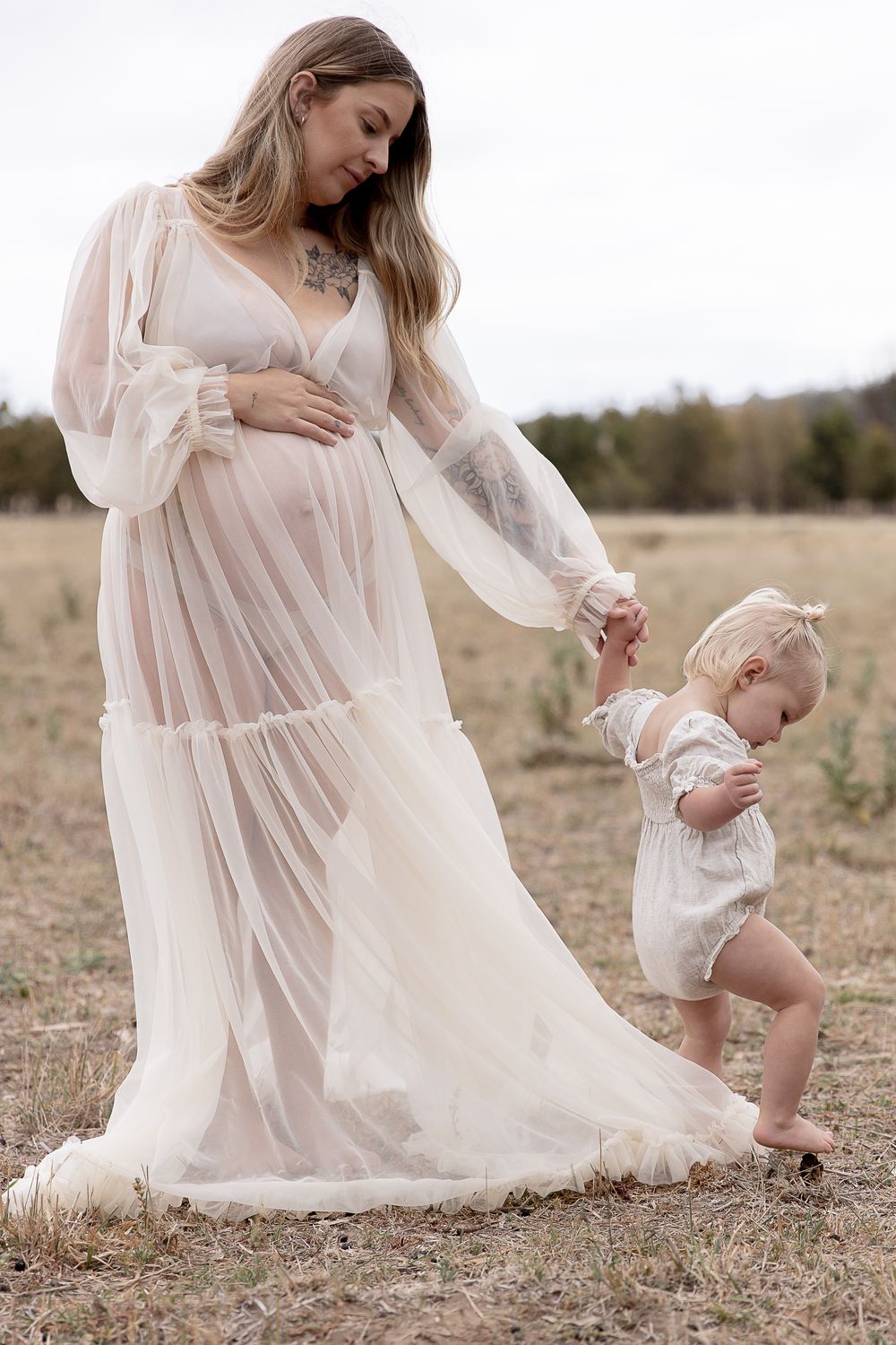 Mother to be and toddler in the paddock during a professional maternity photo shoot.
