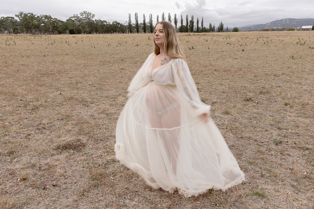 Mother to be twirling in the paddock during a professional maternity photo shoot.