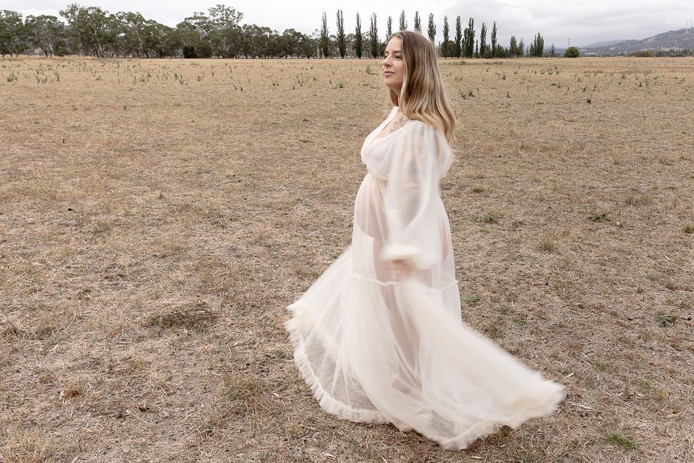 Mother to be twirling in the paddock during a professional maternity photo shoot.