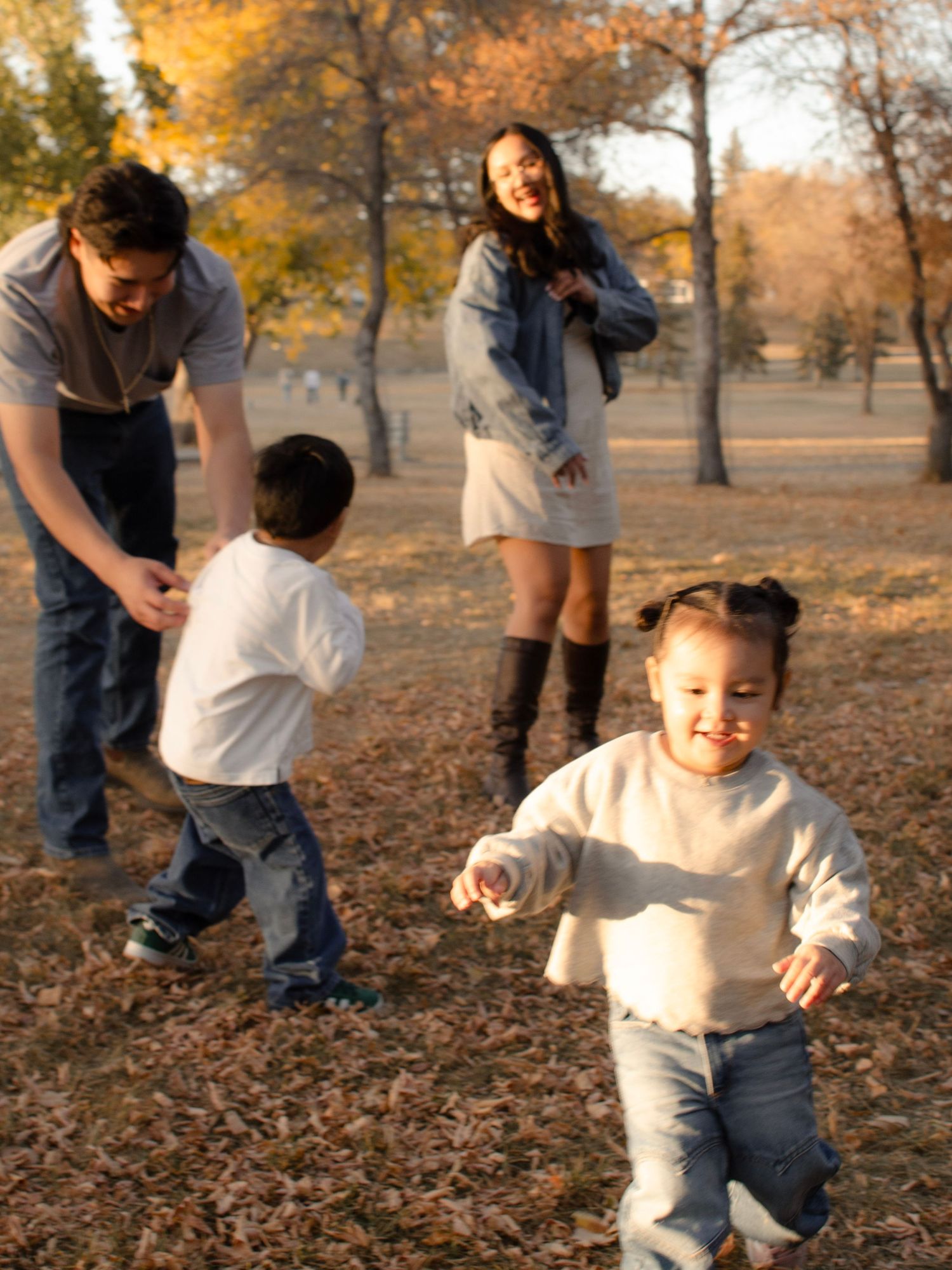 Lifestyle family photography session capturing children laughing outdoors at sunset