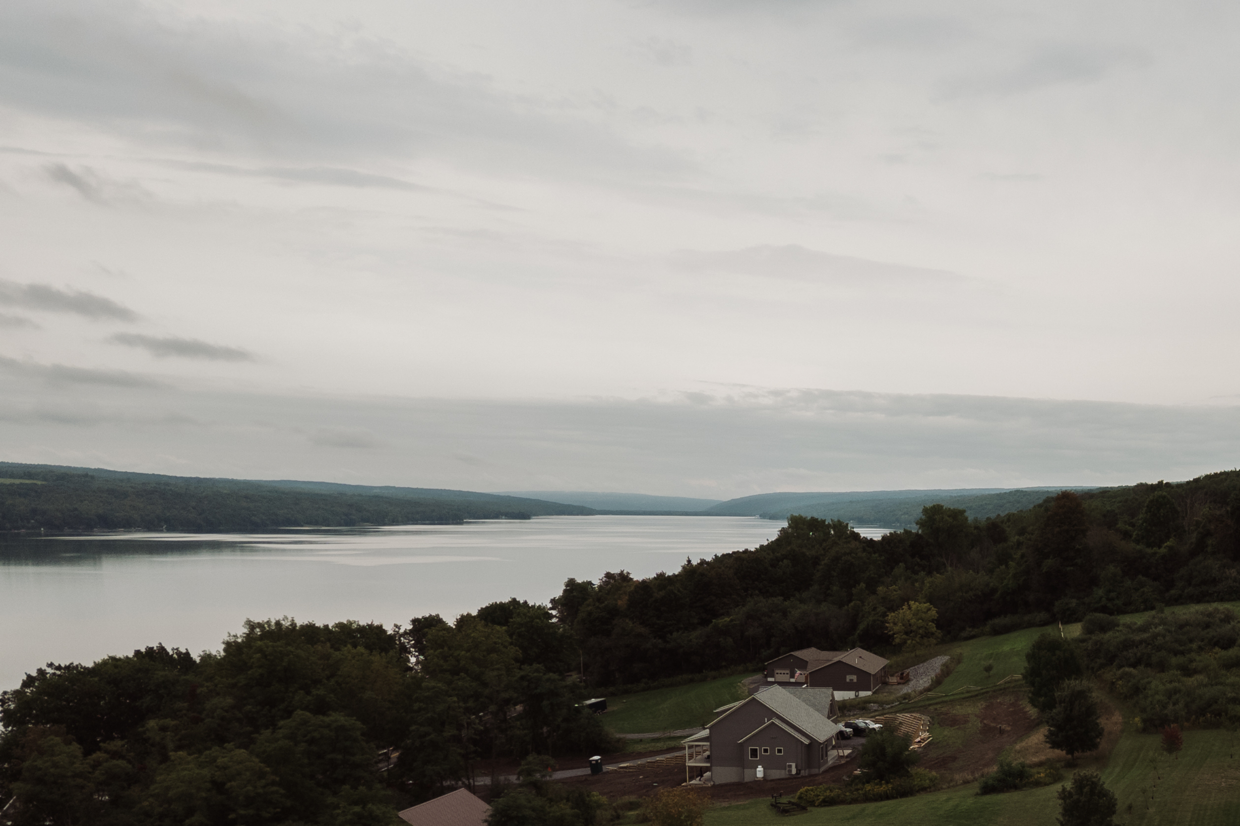 Drone photo of wedding reception at lakeside family property in the Finger Lakes with guests celebrating