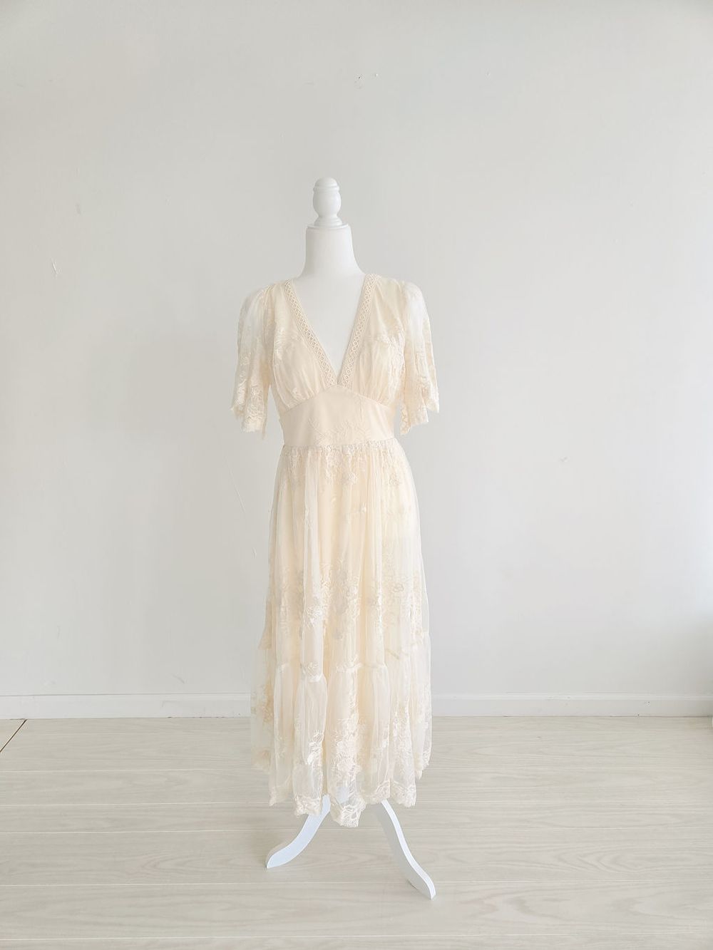 Soft peach empire waist maternity gown with delicate lace overlay shown on mannequin from multiple views.