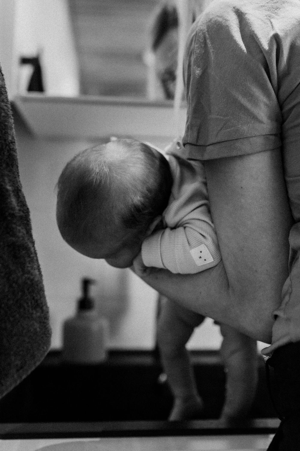 Vastasyntynyt vauva pyllypesulla perheen kotona postpartum- ja vauvakuvauksessa.