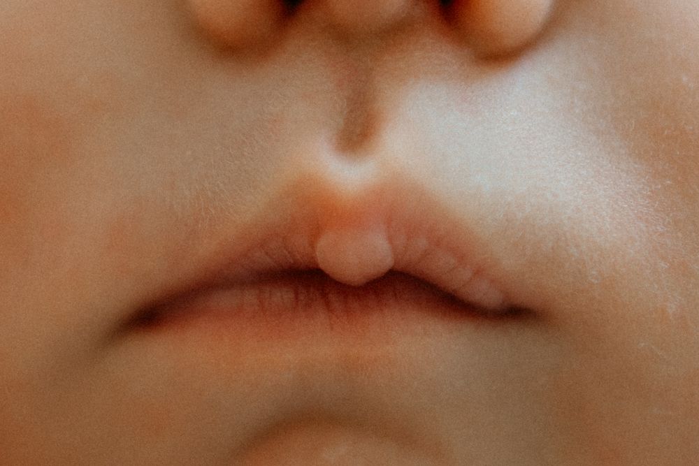 Tarkka lähikuva vastasyntyneen huulista perheen kotona postpartum- ja vauvakuvauksessa.