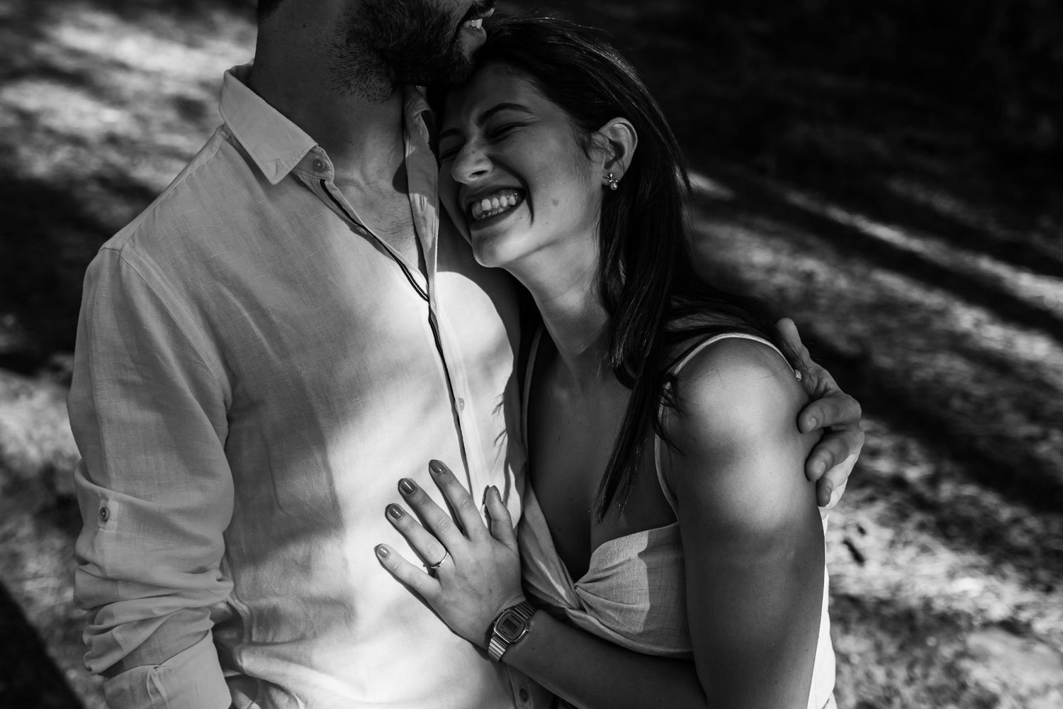 black and white pre-wedding photo of couple laughing during engagement session in Lisbon
