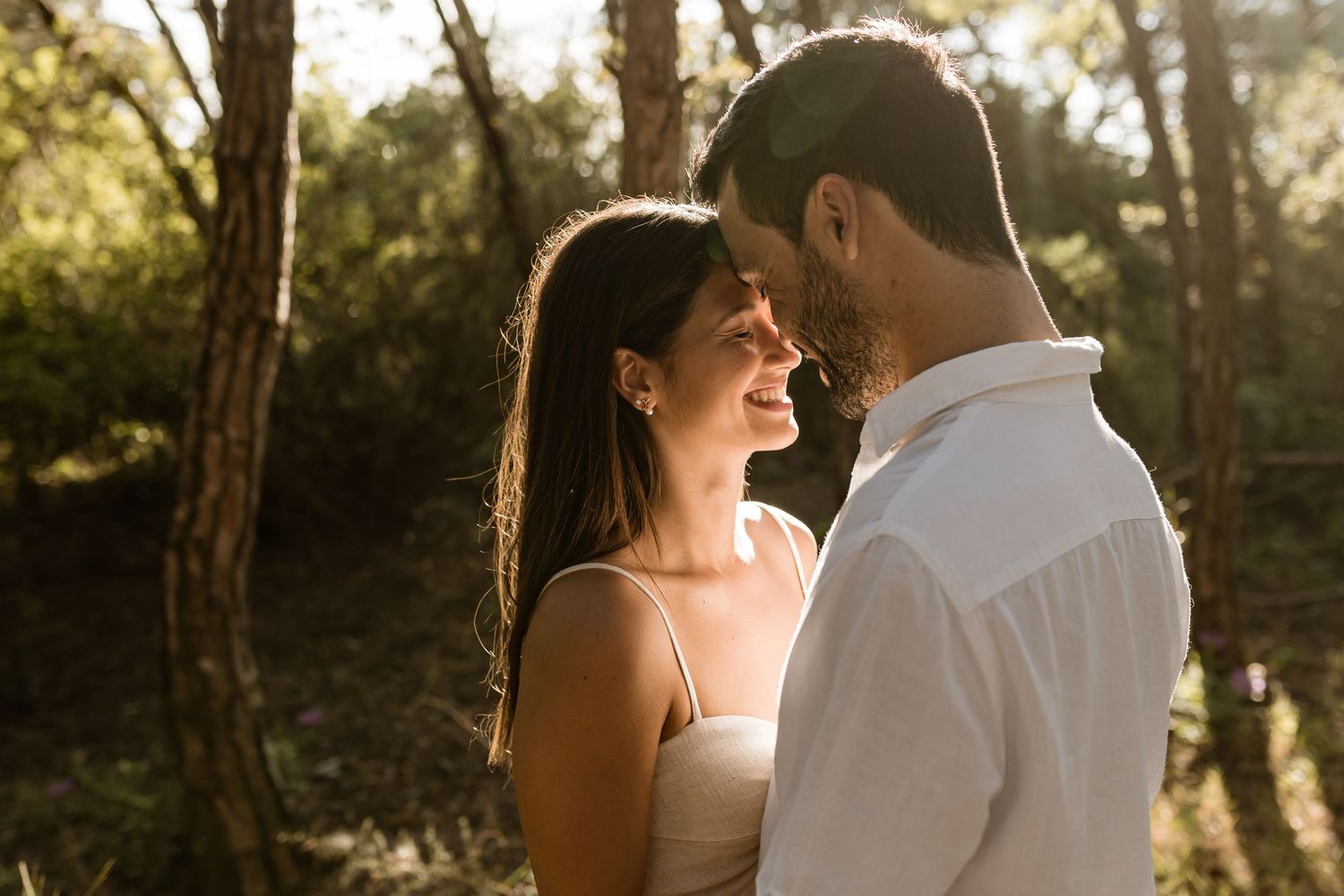intimate engagement session in Lisbon forest with couple smiling and close together