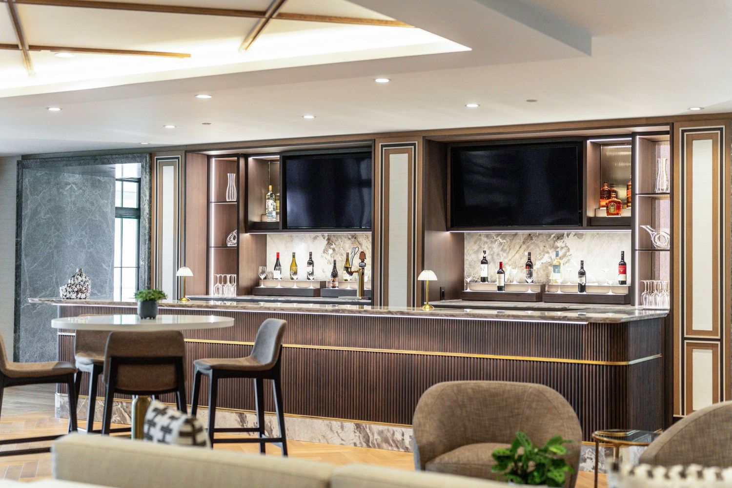 Modern luxury apartment clubhouse interior with sleek bar, lounge seating, and contemporary lighting design.