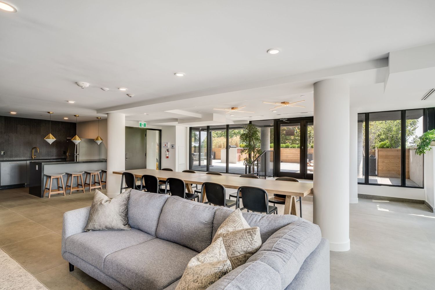 Modern living room interior with grey sectional sofa, recessed lighting, and sleek hardwood floors.