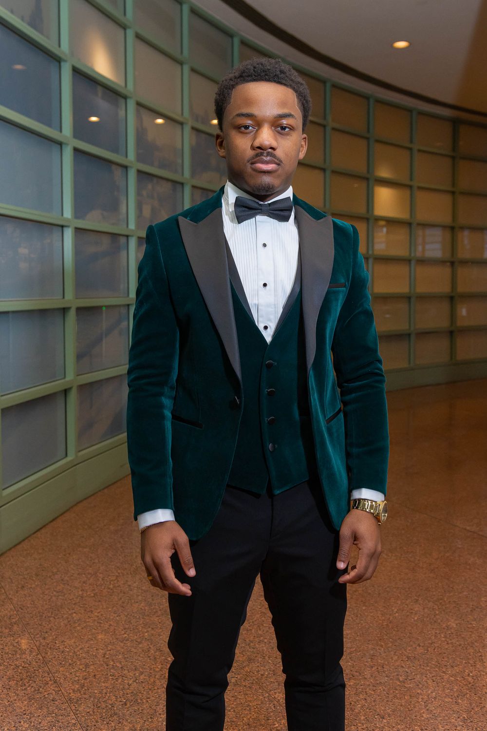 A sequence of formal portraits showing someone in an elegant dark green velvet tuxedo and bow tie.