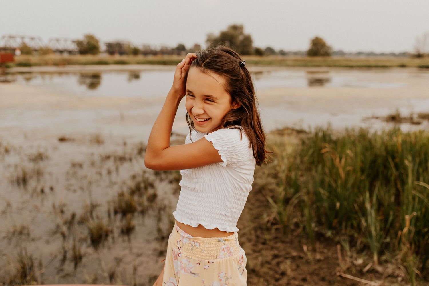 Portrait en extérieur au bord de l’eau, herbes hautes et lumière naturelle douce