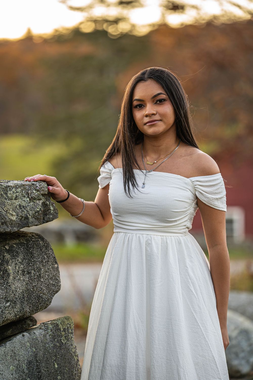A flowing white off-shoulder dress is showcased in multiple angles during an outdoor photoshoot with natural lighting.