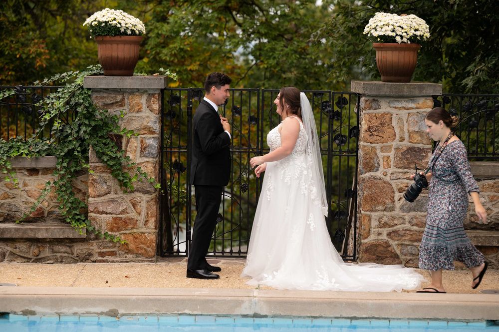 Wedding ceremony sequence showing couple walking along stone wall garden path with white floral arrangements.
