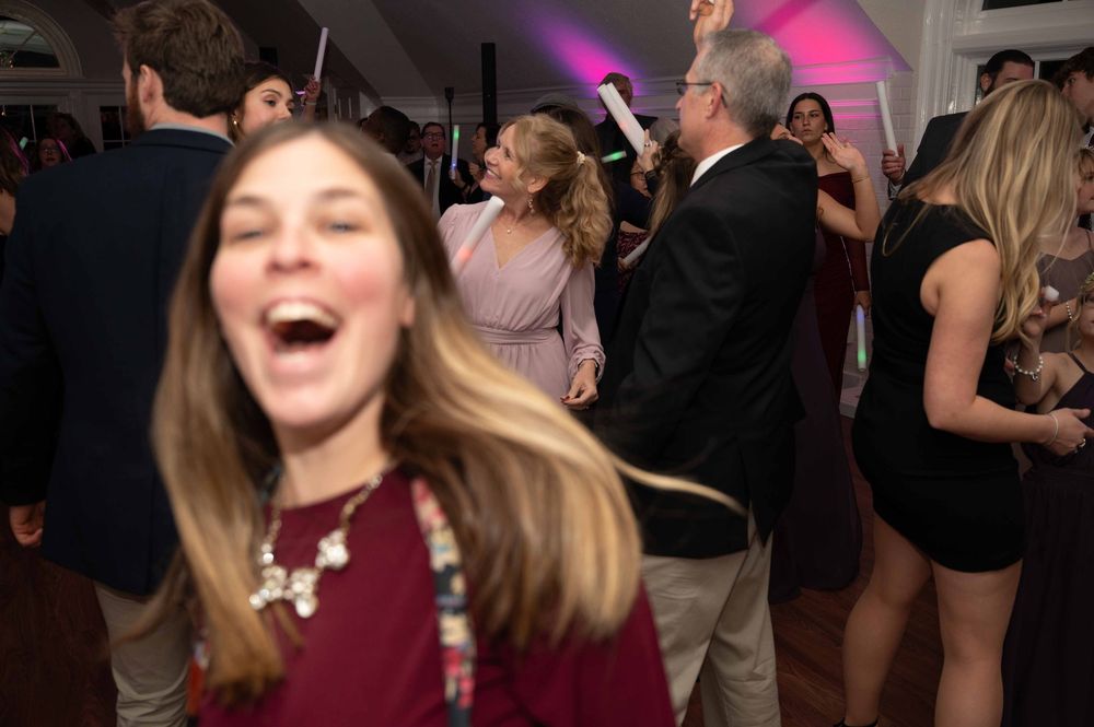 People dancing and celebrating at a lively party with colorful lighting and festive atmosphere.