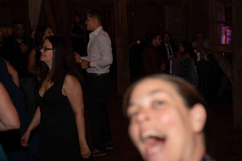 People dancing and celebrating at a dark indoor party or nightclub event.