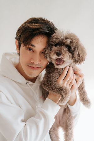 Playful moments with a small brown poodle dog against a white background in a photo series.一組照片中，一隻棕色小貴賓犬在白色背景前嬉戲玩耍。