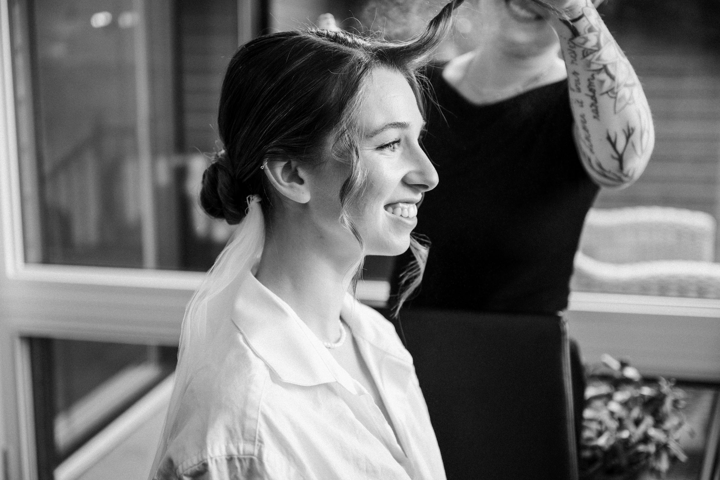 A black and white candid portrait showing a joyful moment with a white button-down shirt and natural lighting.