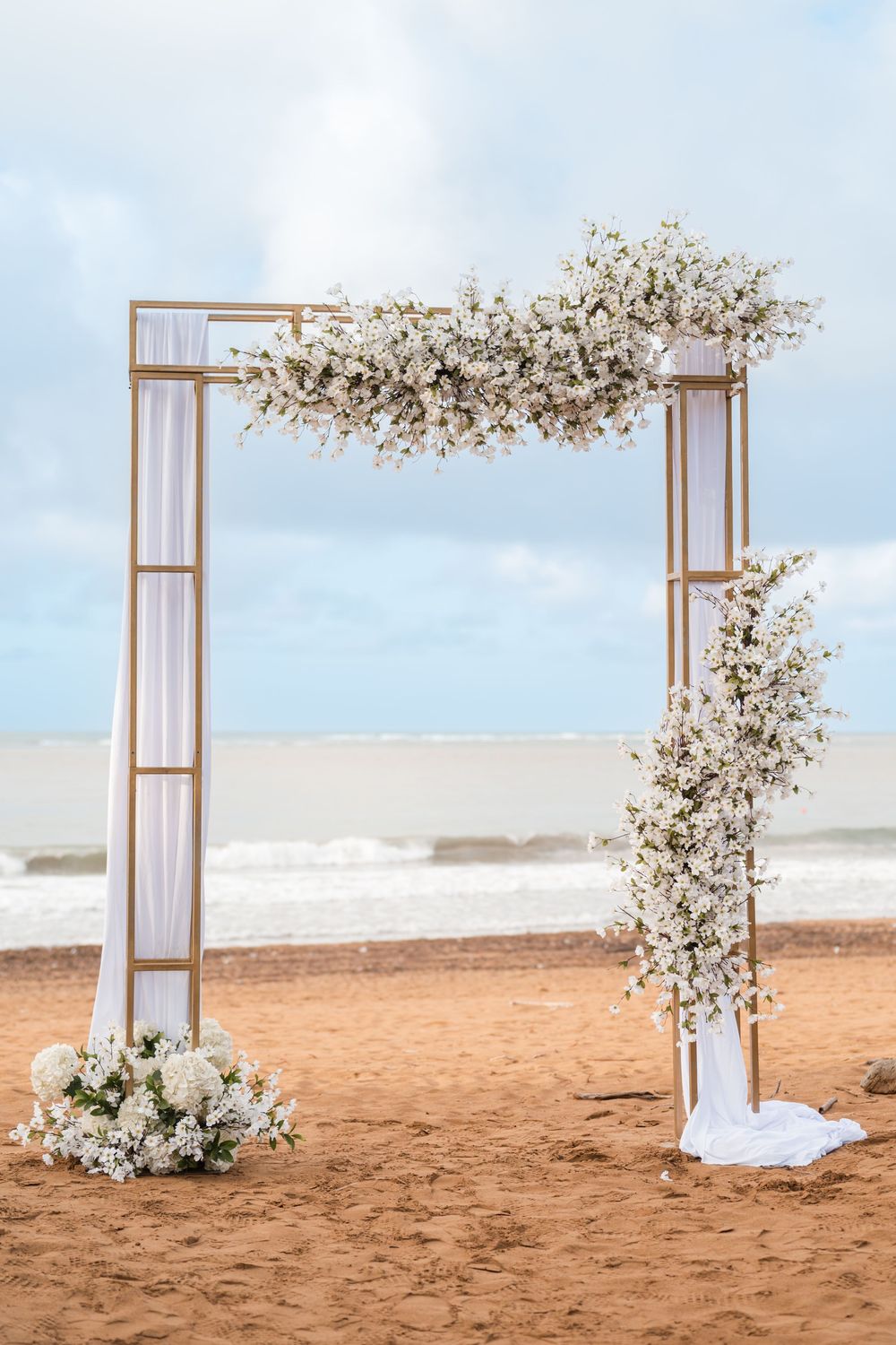 Floral wedding style arch setup on beach at Wyndham Grand Rio Mar Puerto Rico