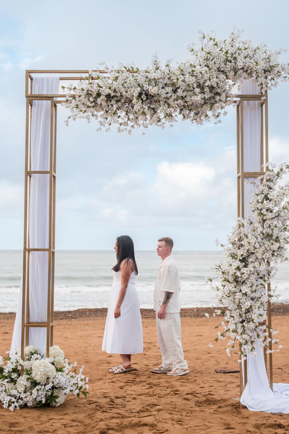 Couple walking together under decorated arch during engagement photos at Wyndham Rio Mar in Rio Grande Puerto Rico