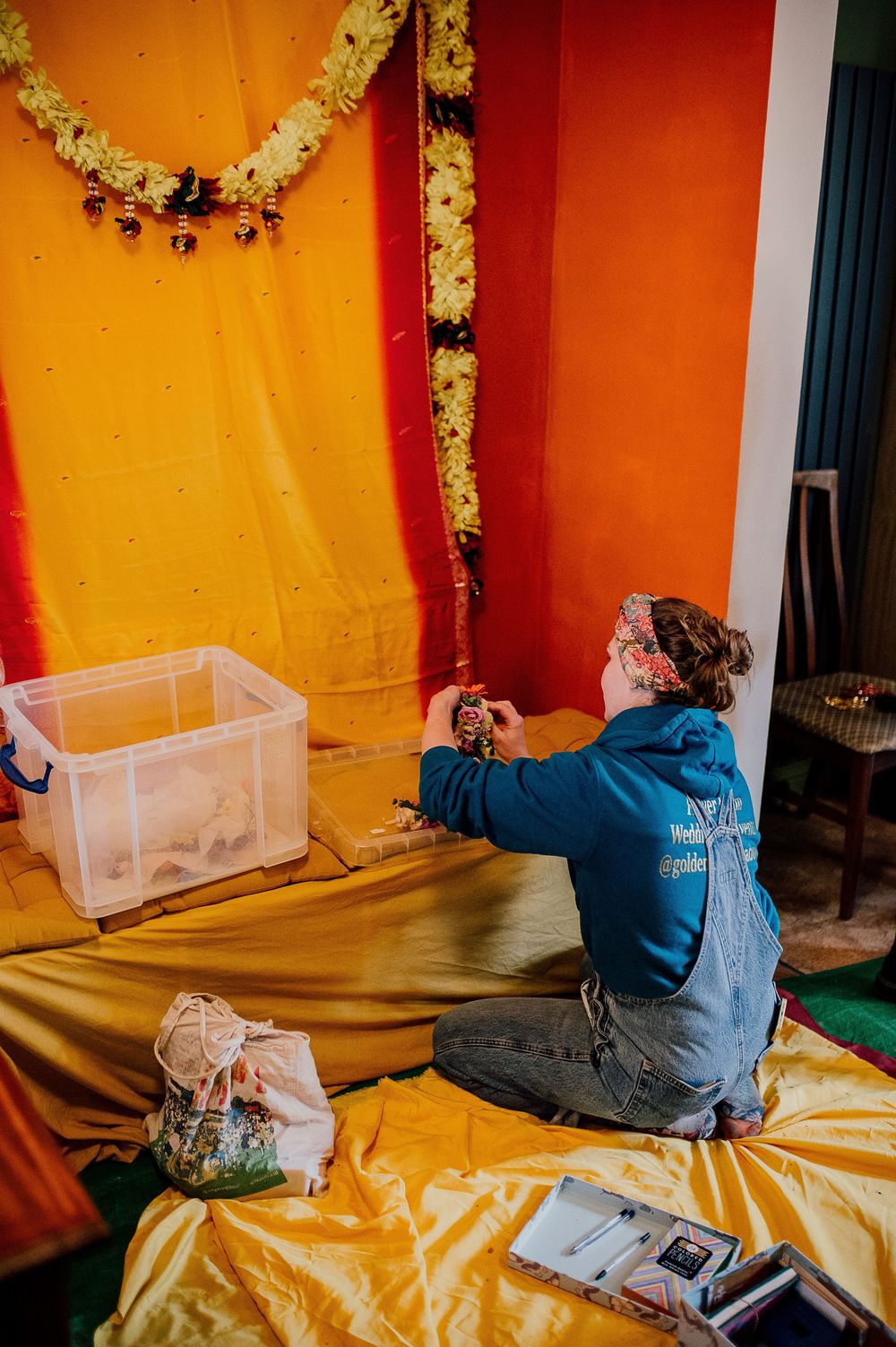 Person in blue jacket lying on yellow surface next to clear plastic storage container in progressive sequence.