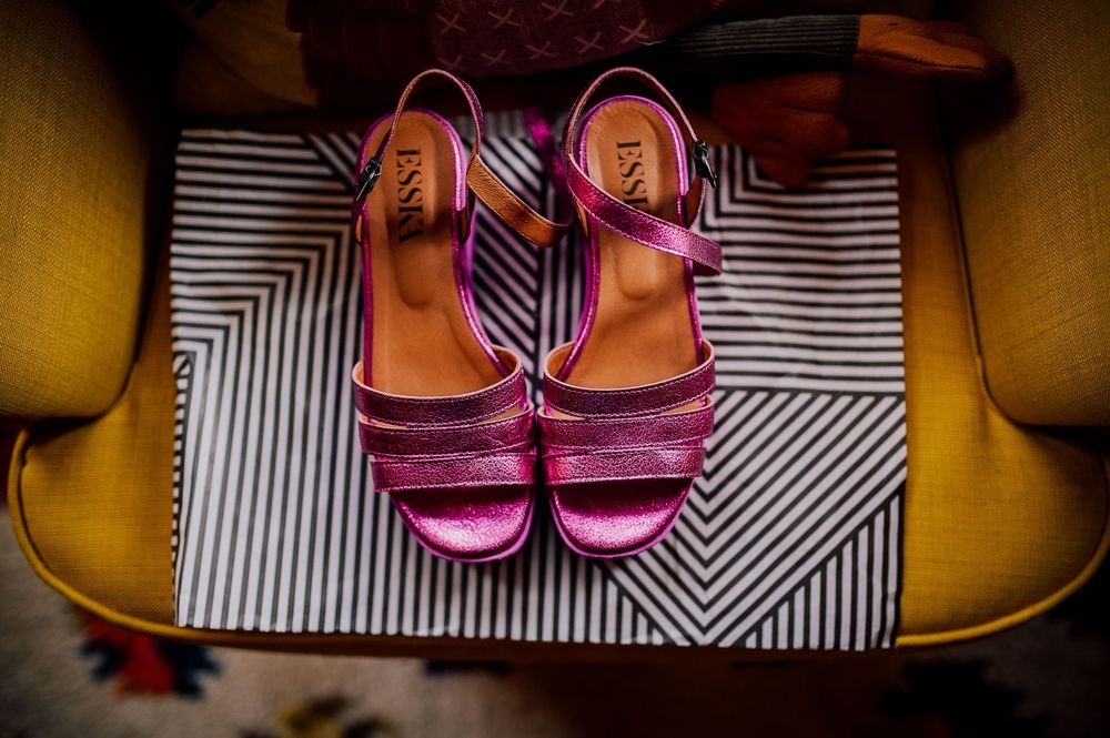 A collection of colorful shoes arranged in a row against a black and white striped background.