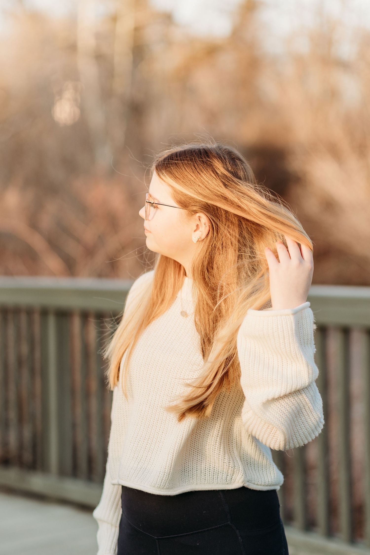 Woman in white sweater flips her blonde hair in sequence of artistic motion shots against autumn backdrop.